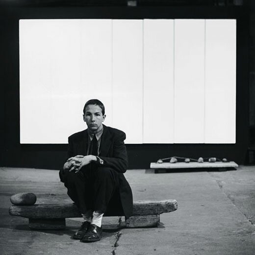 Robert Rauschenberg sits in front of his 